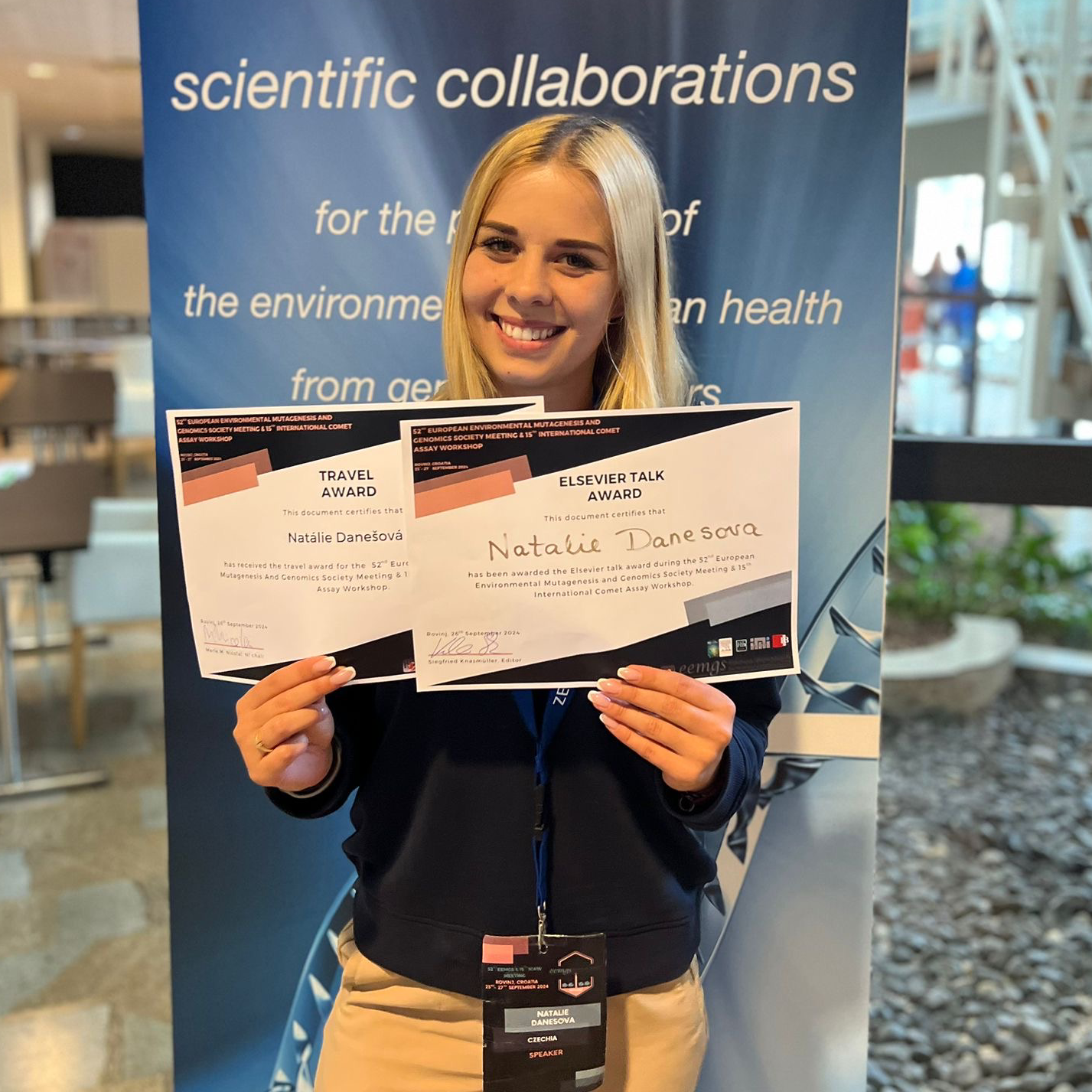 Photo of the awarded PhD student Natália Danešová holding the Elsevier Talk Award and Travel Award certificates